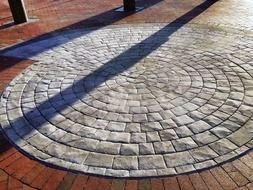 grey cobblestone pattern on red brick pavement