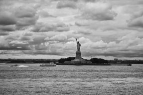 statue of liberty at clouds, distant view from sea, usa, manhattan, new york city