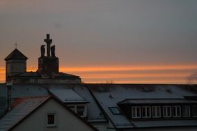 Church steeple and houses roof at sunset