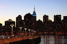 pier on water in view of city skyline at dusk, usa, manhattan, nyc