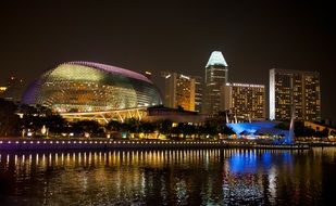 night view of the Singapore city buildings, their reflection in the sea (straits)