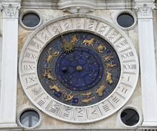 antique astronomical clock on facade, italy, Venice