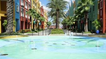 fountain on street and palm trees at colorful houses, netherlands, curacao, willemstad