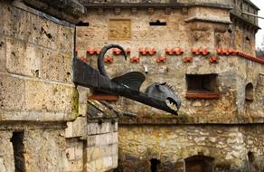 gargoyle, metal dragon on stone facade of castle, germany, lichtenstein