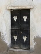 black door with four white hearts