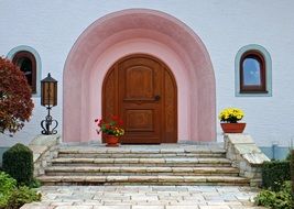 wooden door in arched doorway above stairs, old beautiful stone facade