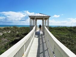 people on wooden walkway at ocean, usa, florida