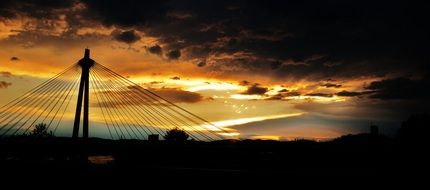 silhouette of suspension bridge at sunset sky