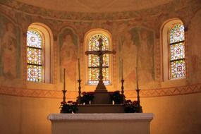 altar against the background of colorful windows in the interior of the cathedral