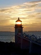 lighthouse signal at sunset sky above sea