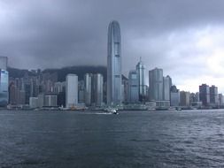 skyline with clouds above skyscrapers at water, china, hong kong