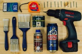 hand tools, beer cane and cigarettes on wooden desk