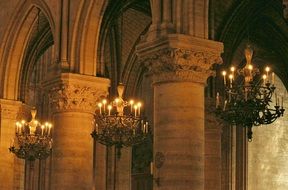 wrought iron chandeliers under gothic ceiling