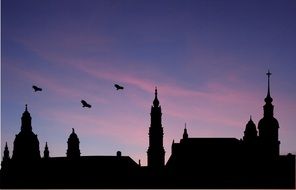 Black silhouettes of the church and birds at colorful evening sky background