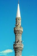 top of ancient grey stone minaret at sky, turkey