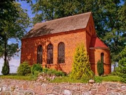 small red brick church building at summer, poland