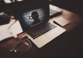 home office, laptop on desk with the cup image on the screen