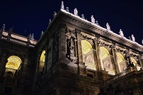 ornated facade with stone carving and sculptures at night, hungary, budapest