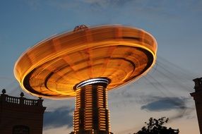 illuminated carousel at evening sky, long exposure