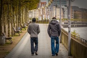 two young men walking on rhine waterfront, germany, dÃ¼sseldorf