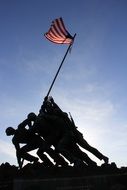 silhouette of monument to soldiers with american flag