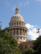 dome of capitol building and flags at sky, usa, texas, austin