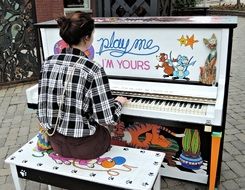 girl playing painted piano on street, canada