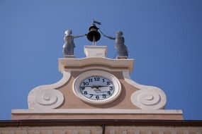 clock with metal figures on top of building