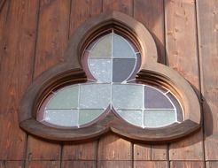 stained glass in floral form window on wooden facade