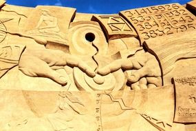 two hands touching pointing fingers, sand sculpture