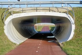 red road in white tunnel under bridge