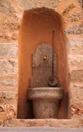 ancient stone fountain on facade, spain, mallorca