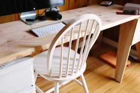 wooden chair at computer desk in office