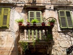 pots with plants on balcony of old house, croatia