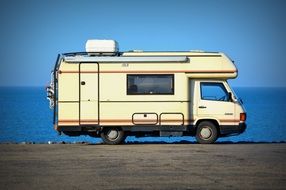 mobil home, yellow camper van at blue sea