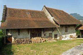 piles of chopped wood at old farm buildings in france