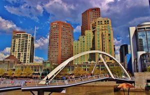 people walking on pedestrian bridge at colorful modern cityscape, australia, melbourne