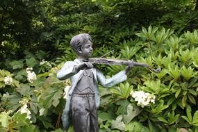 child boy playing violin, metal sculpture in park, australia, victoria, mount macedon