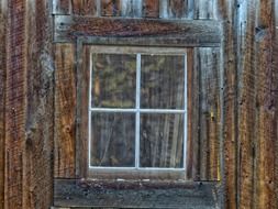 window on old brown wooden wall close-up