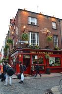 people with bags on street at the temple bar, uk, ireland, dublin