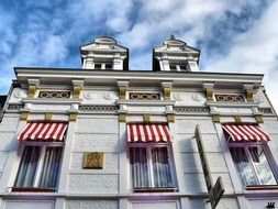 old facade with striped canopies on windows, netherlands, valkenburg