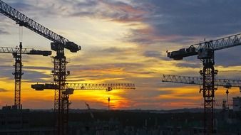 silhouettes of tower cranes at sunset sky, singapore