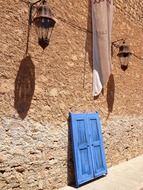 old street lanterns on wall above blue frame with shutters, spain, mallorca