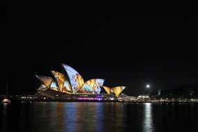 colorful illuminated sydney opera house on harbor at night, australia