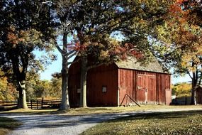 red wooden barn in countryside at autumn