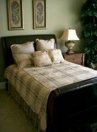 wooden bed with pillows in vintage interior of bedroom