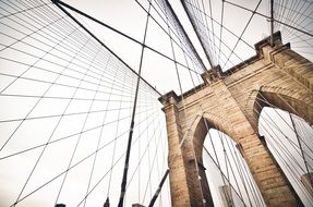 steel ropes of suspension brooklyn bridge at grey sky, usa, manhattan, new york city