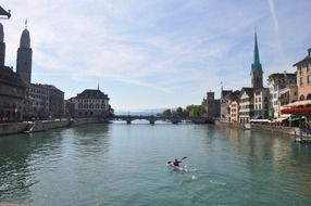 man in kayak on river in old city, switzerland, zürich