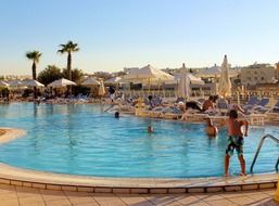 people resting at luxury swiming pool, malta, intercontinental hotel