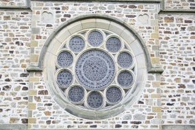 rosette window on wild stone church facade